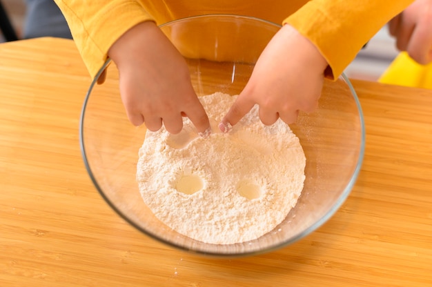 Bambino di alta vista che fa una faccia nella ciotola