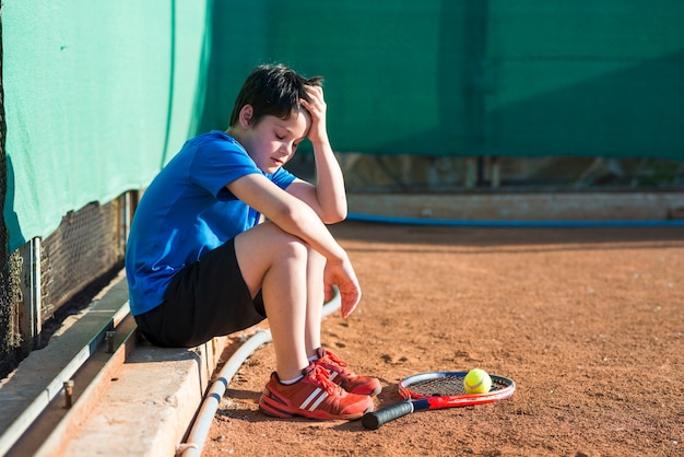 Bambino di lato seduto dopo la partita