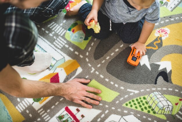 Bambino di mangiare una mela e giocare con una macchinina giocattolo