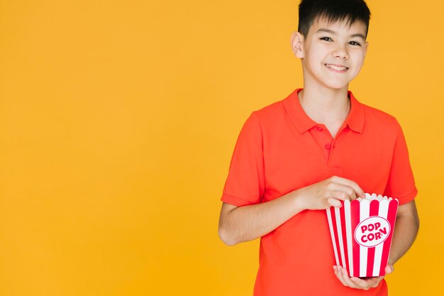 Bambino di smiley che mangia popcorn con lo spazio della copia