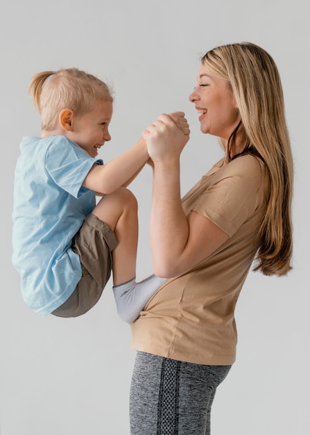 Bambino di smiley della holding della donna del colpo medio