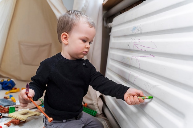 Bambino di tiro medio che gioca con i pastelli