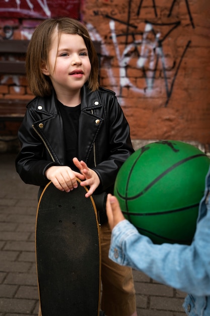 Bambino di vista frontale che tiene skateboard