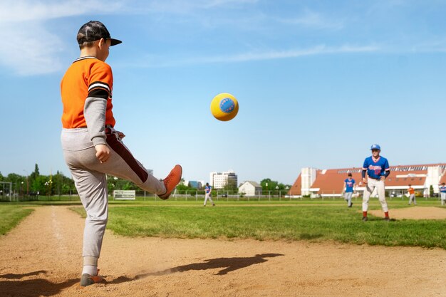 Bambino di vista laterale che dà dei calci alla palla