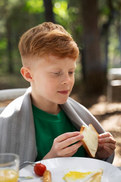 Bambino di vista laterale che mangia in natura