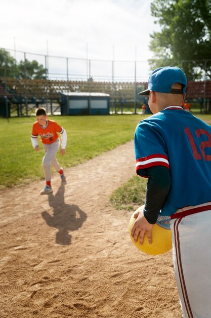 Bambino di vista laterale che tiene palla gialla