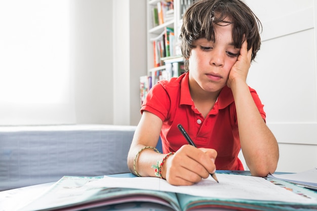 Bambino disegno su carta al tavolo