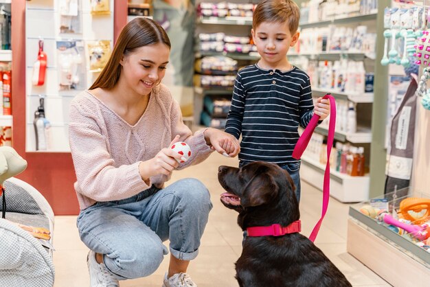 Bambino e madre al negozio di animali con il loro cane