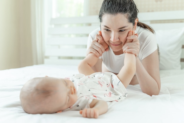 Bambino e mamma addormentati che giocano con i piedi del bambino