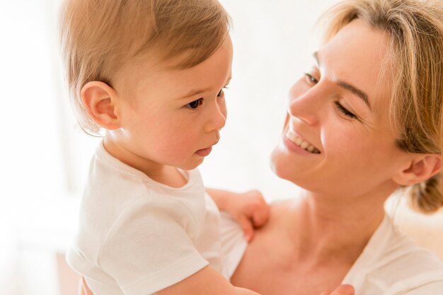 Bambino e sorridere della tenuta della donna del primo piano