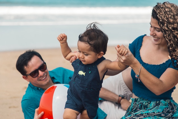 Bambino facendo i primi passi con la madre in riva al mare