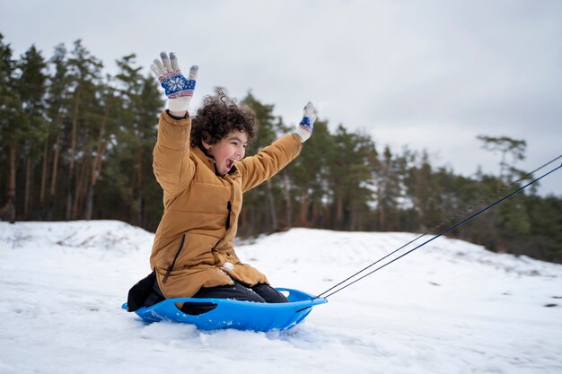 Bambino felice a tutto campo che si diverte in inverno