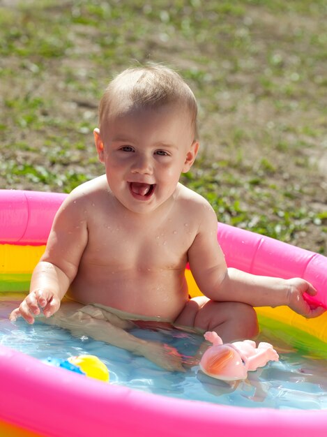 Bambino felice di nuoto in bambino gonfiabile