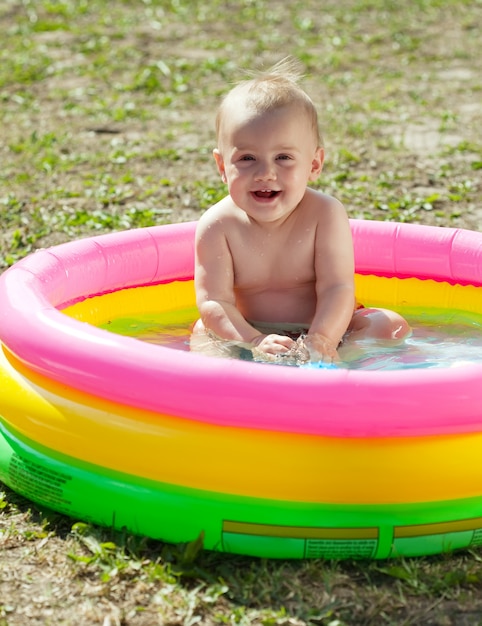 Bambino felice di nuoto in piscina gonfiabile