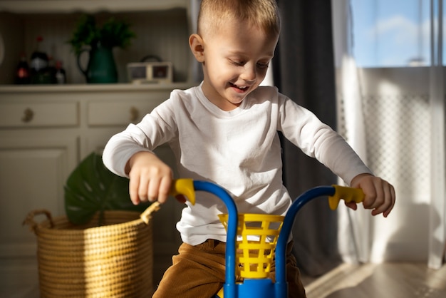 Bambino felice di tiro medio sul triciclo