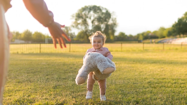 Bambino felice in abiti rosa e orsacchiotto a tiro lungo