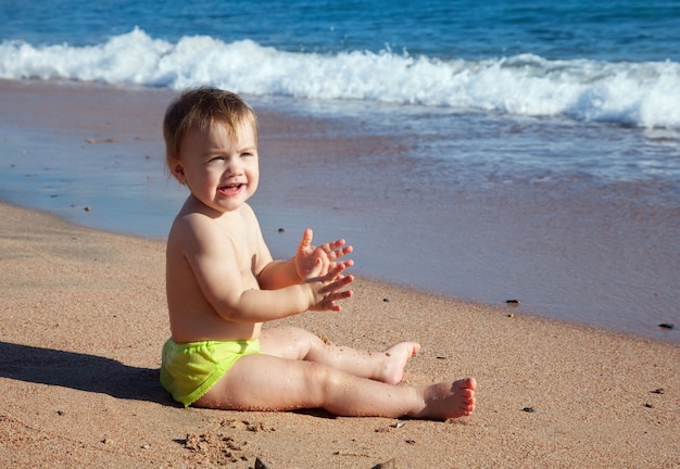 Bambino felice sulla spiaggia di sabbia