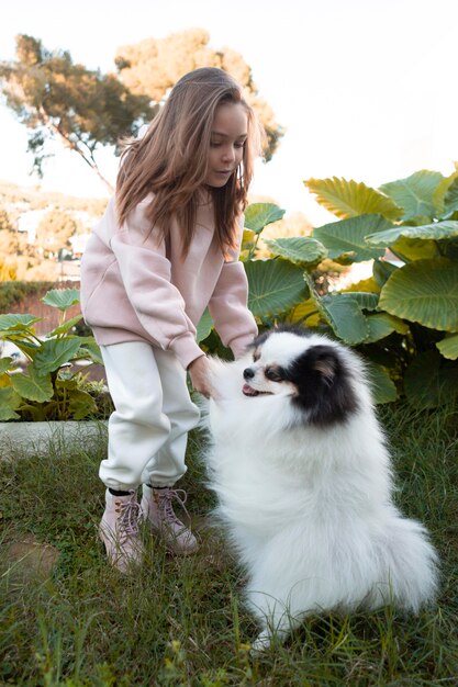 Bambino femminile e cane lanuginoso che giocano