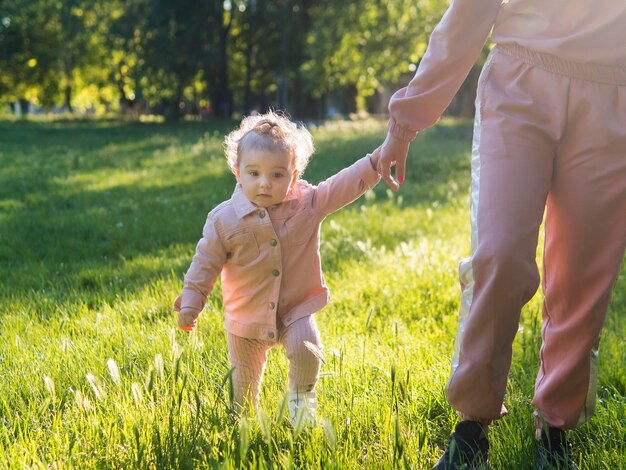 Bambino in abiti rosa in piedi sull'erba