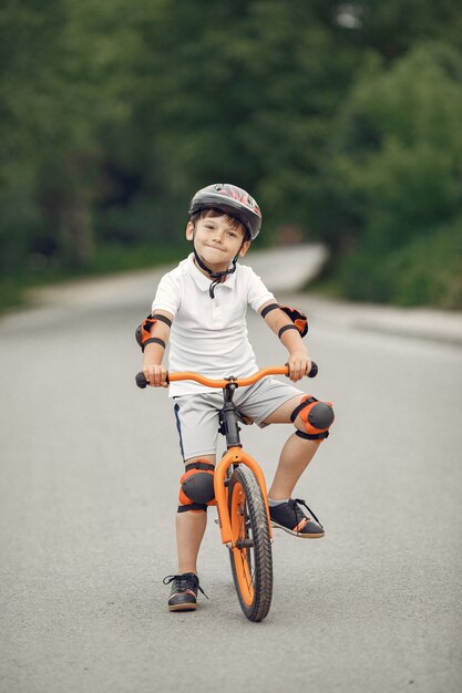 Bambino in bicicletta in strada asfaltata in estate. Bike nel parco