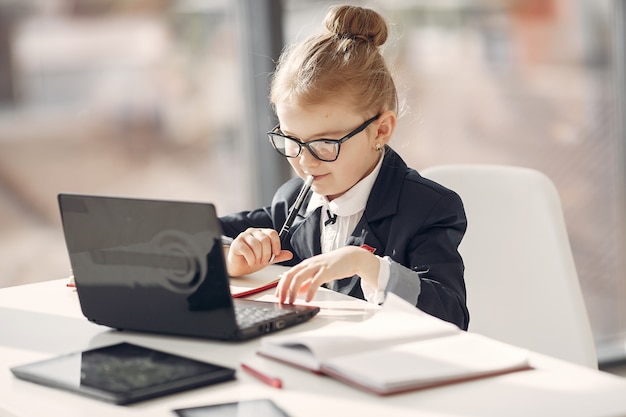 Bambino in ufficio con un computer portatile