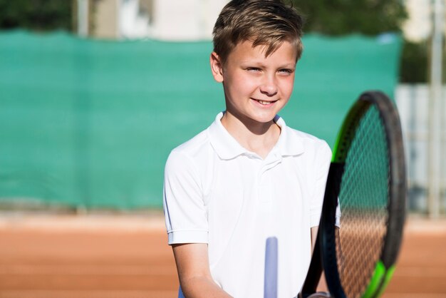 Bambino medio sparato che gioca a tennis