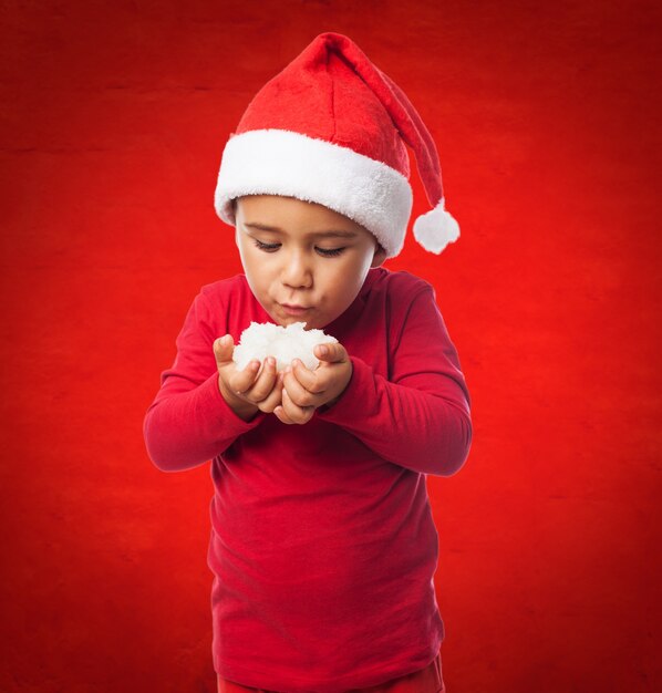 Bambino neve che soffia in uno sfondo rosso