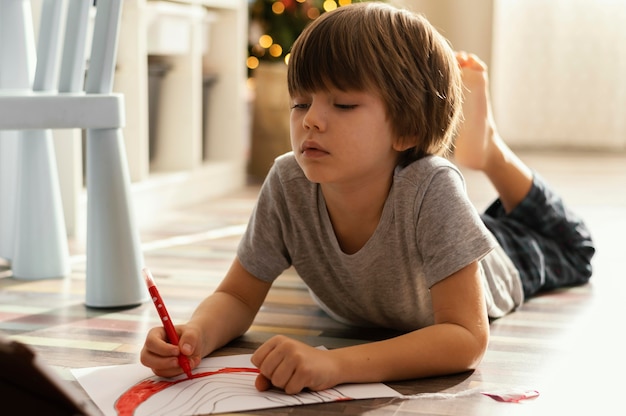 Bambino pieno del colpo che disegna sul pavimento