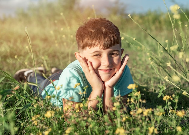 Bambino pieno del colpo che si siede sull'erba