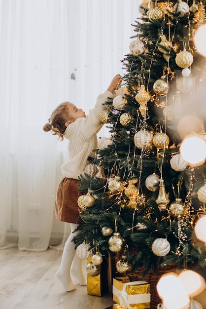 Bambino seduto sotto l'albero di Natale