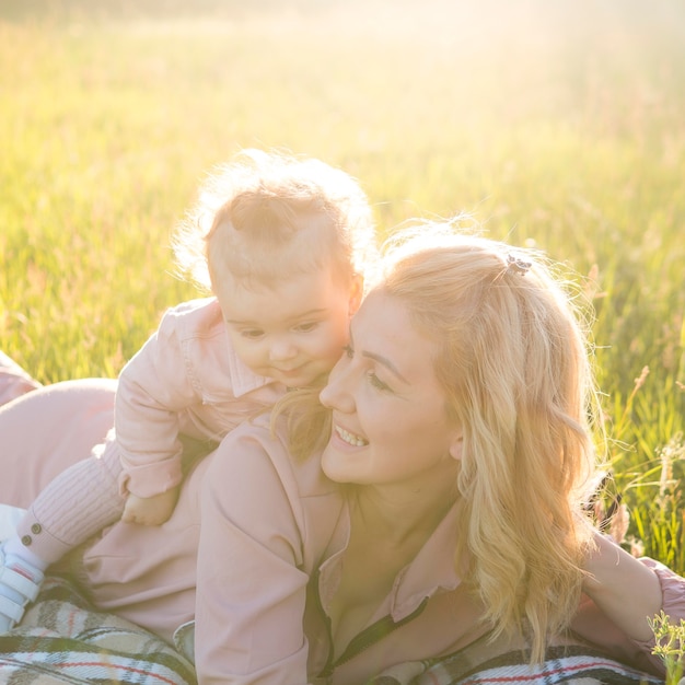 Bambino seduto sulla schiena della mamma ed essere felice