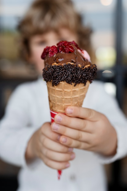 Bambino sfocato vista frontale che tiene il gelato