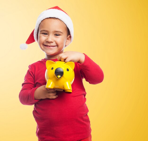 Bambino sorridente con il suo salvadanaio