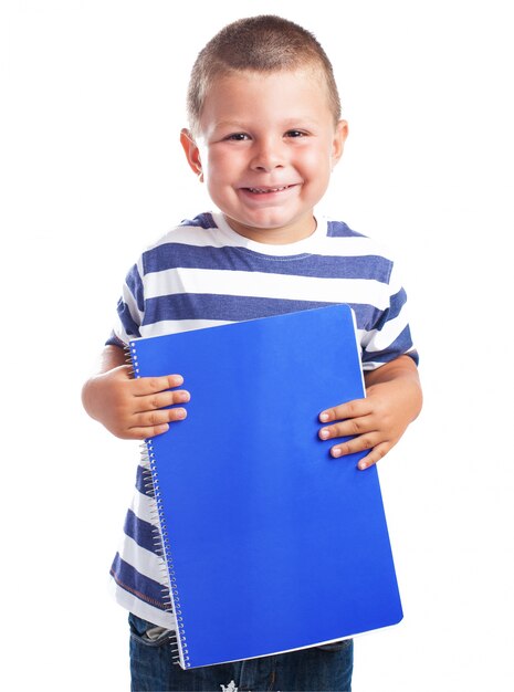 Bambino sorridente con un notebook blu