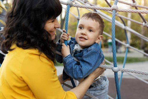 Bambino sorridente della holding della madre di vista laterale