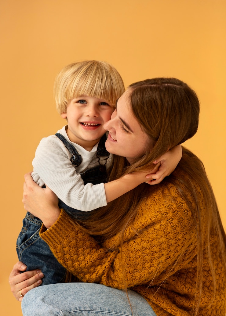 Foto gratuito bambino sorridente della holding della madre di vista laterale