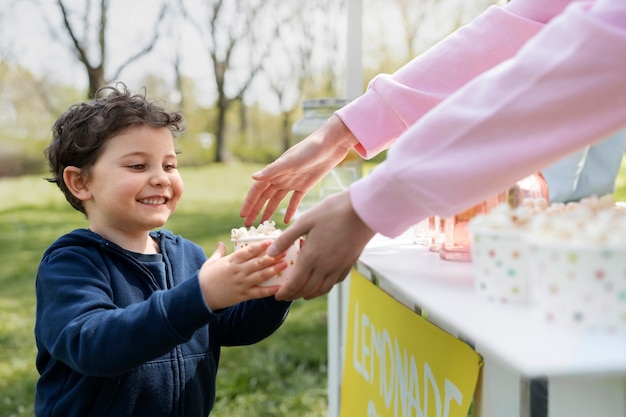 Bambino sorridente di vista laterale che compra popcorn