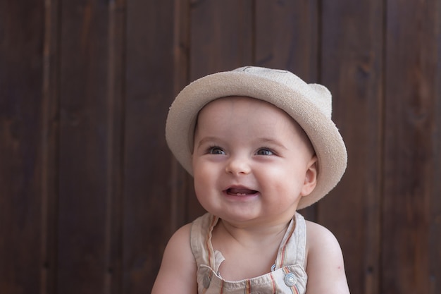 Bambino sorridente in cappello estivo.