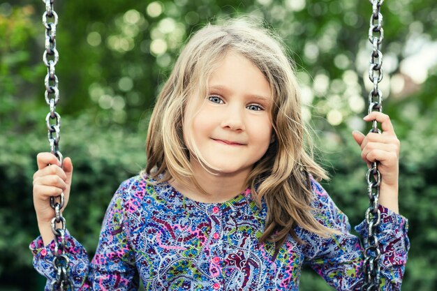 Bambino su altalena nel parco estivo