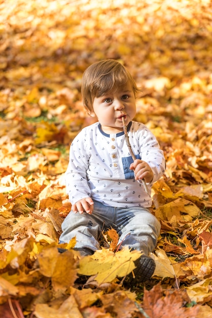 Bambino sveglio della foto a figura intera che gioca con il bastone