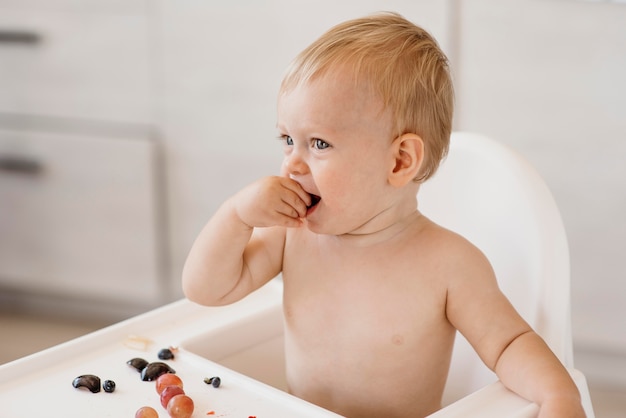 Bambino sveglio di vista laterale che mangia da solo