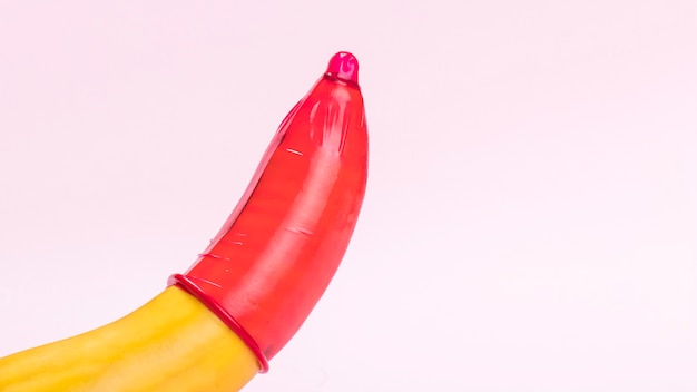 Banana con preservativo rosso e copia-spazio