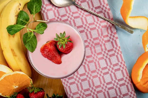 Banana fresca, arancia e fragole con una ciotola di budino