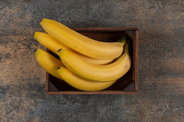 Banane mature nella scatola, sulla superficie del marmo