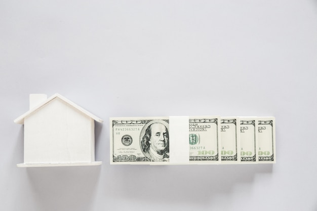 Banconota del dollaro di vista superiore con la casa di legno, concetto di finanza