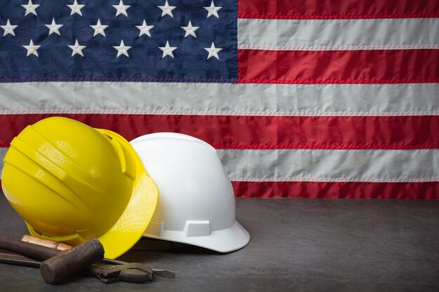 Bandiera americana e strumenti vicino al concetto di festa del lavoro del casco.