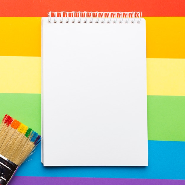 Bandiera dell'orgoglio arcobaleno con blocco note e pennello