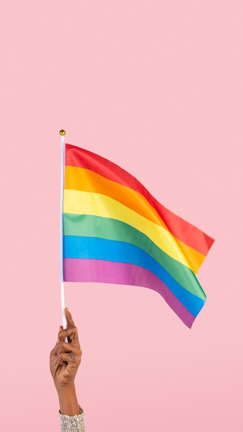 Bandiera dell'orgoglio LGBTQ+ con alzata di mano della donna