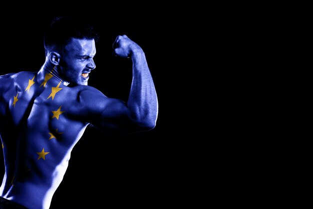 Bandiera dell'Unione europea sul bel giovane uomo muscoloso sfondo nero