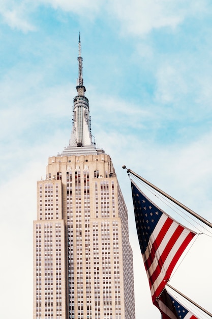 Bandiera USA che fluttua vicino all&#39;Empire State Building